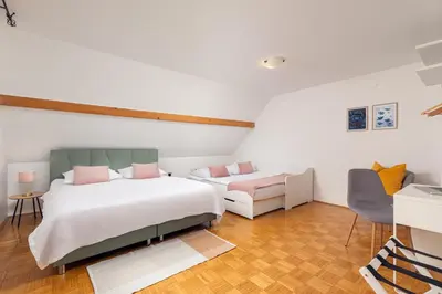 a bedroom with two beds and a chair at HoMEMADE in Ljubljana