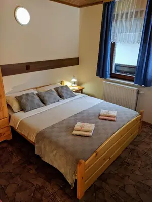 a bedroom with a large bed with two towels on it at Apartma Kramar Podkoren in Kranjska Gora