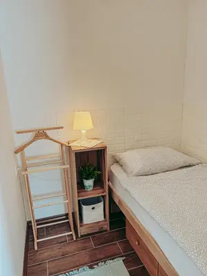 a room with two beds and a lamp on a table at Apartments Ivanović in Idrija