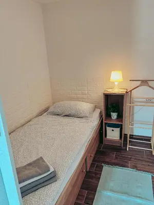 a bed in a room with a lamp and a table at Apartments Ivanović in Idrija