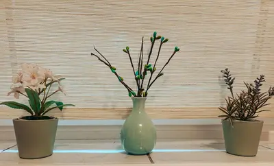 three vases with flowers in them sitting on a table at Apartments Ivanović in Idrija