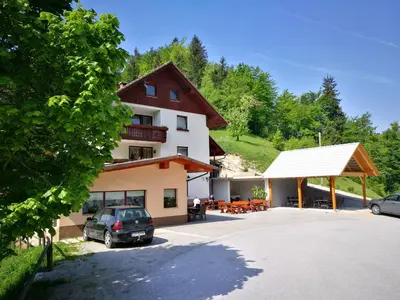 a building with a car parked in a parking lot at Apartma Teloh in Kopačnica