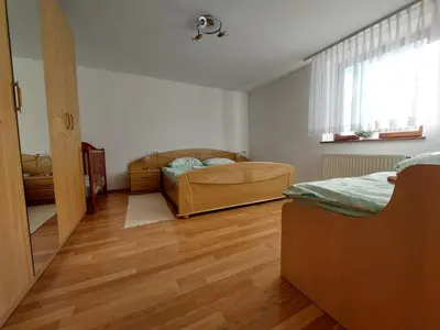 a bedroom with a bed and a wooden floor at Apartma Teloh in Kopačnica