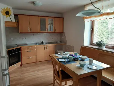 a kitchen with a wooden table with dishes on it at Apartma Teloh in Kopačnica