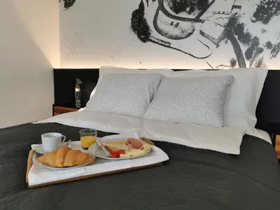 a tray with two plates of food on a bed at Hotel CityMap Maribor in Maribor