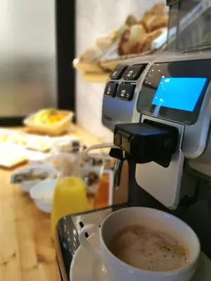 a coffee maker is making a cup of coffee at Hotel CityMap Maribor in Maribor