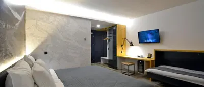a hotel room with a bed and a couch at Hotel CityMap Maribor in Maribor