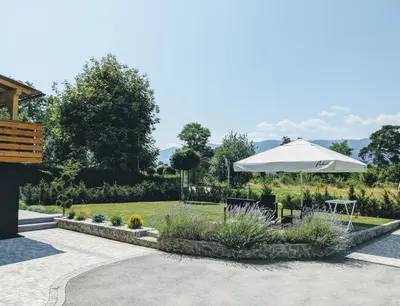a patio with an umbrella and a table and chairs at Deluxe Apartments Panorama in Lesce
