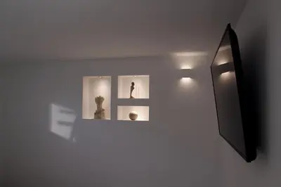 a wall with three pictures of a statue and a mirror at Deluxe Apartments Panorama in Lesce