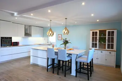 a kitchen with white cabinets and a table with chairs at Domačija KOHOVO in Lovrenc na Pohorju