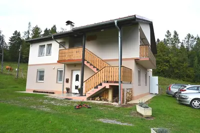 a house with a balcony and a staircase on it at Domačija KOHOVO in Lovrenc na Pohorju