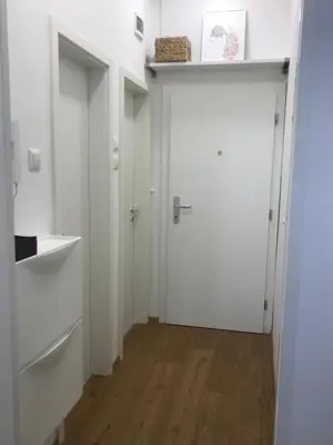 a hallway with two white doors and a wooden floor at My Nest, 5 minutes to the Dragon Bridge in Ljubljana