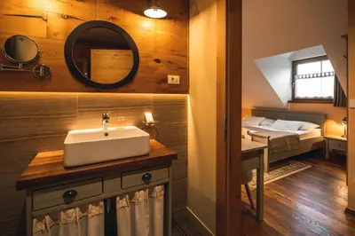 a bathroom with a sink and a bed in a room at Hotel Zamorc in Škofja Loka