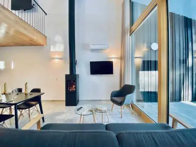 a living room with a blue couch and a fireplace at Apartments Cokla Zero in Zreče
