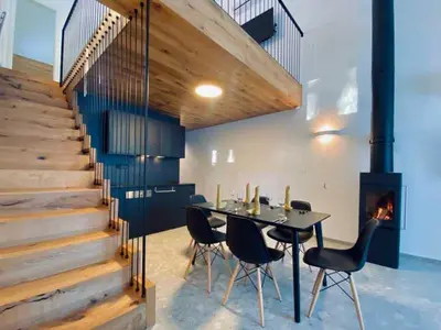 a dining room with a table and chairs and a fireplace at Apartments Cokla Zero in Zreče
