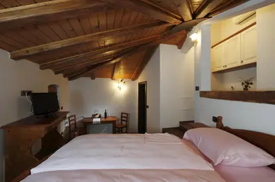 a bedroom with a large bed and wooden ceilings at Pri Marjotu in Kojsko