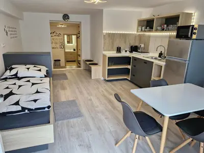 a bedroom with a bed and a table and chairs at Apartma Vovk in Mojstrana