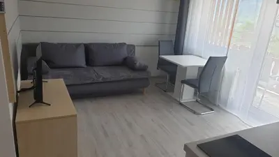 a living room with a couch and a table at Apartma Vovk in Mojstrana