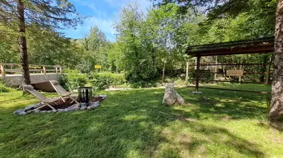 a garden with a bench and a tree at Vila Rozi, Osilnica - vacation house Pr' Vili Rozi in Osilnica