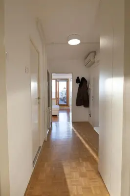 a hallway with white walls and a hard wood floor at Bright Penthaus Apartement, with a wonderful view in Ljubljana