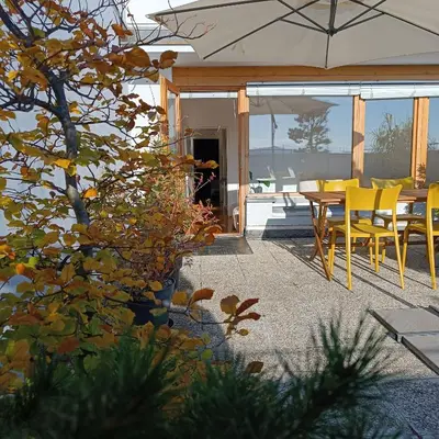 a patio with yellow chairs and a table with an umbrella at Bright Penthaus Apartement, with a wonderful view in Ljubljana