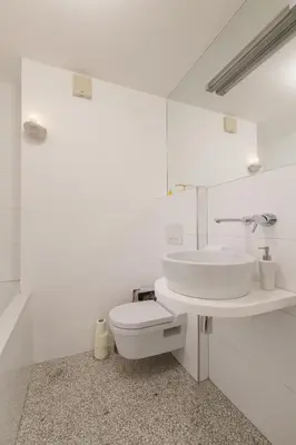 a white bathroom with a sink and a toilet at Bright Penthaus Apartement, with a wonderful view in Ljubljana