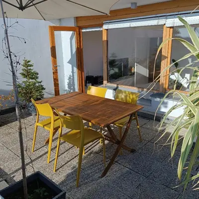 a wooden table and chairs on a patio at Bright Penthaus Apartement, with a wonderful view in Ljubljana