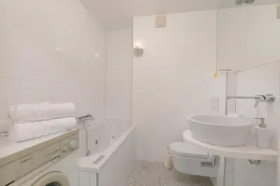 a white bathroom with a sink and a toilet at Bright Penthaus Apartement, with a wonderful view in Ljubljana