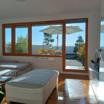 a bedroom with a bed and a large window at Bright Penthaus Apartement, with a wonderful view in Ljubljana