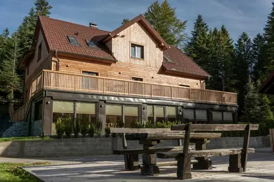 a wooden house with a bench in front of it at House Storz in Pohorje