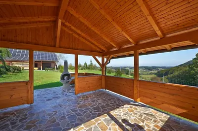 a large wooden pavilion with a fireplace on a patio at Farmhouse Lipoglav in Loče pri Poljčanah