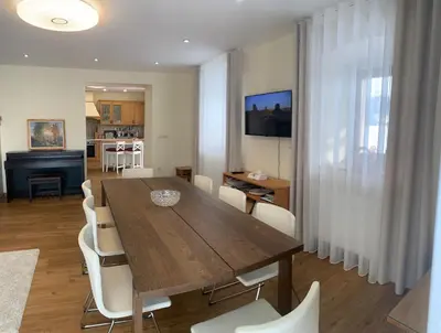 a dining room with a wooden table and white chairs at Farmhouse Lipoglav in Loče pri Poljčanah