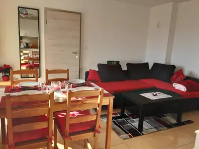 a living room with a red couch and a table at Apartments Barbi in Bled