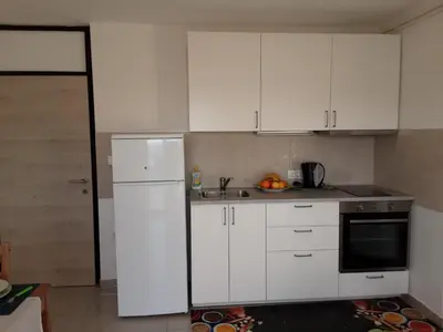 a kitchen with white cabinets and a sink at Apartments Barbi in Bled