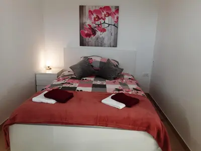 a bedroom with a bed with a red blanket at Apartments Barbi in Bled