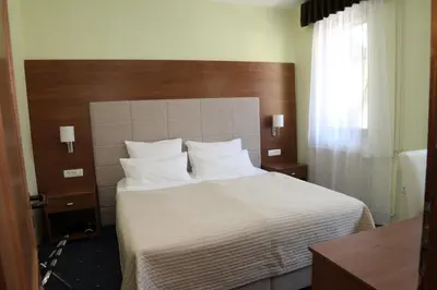 a bedroom with a large bed with white sheets and pillows at Penzion Zaka in Bled