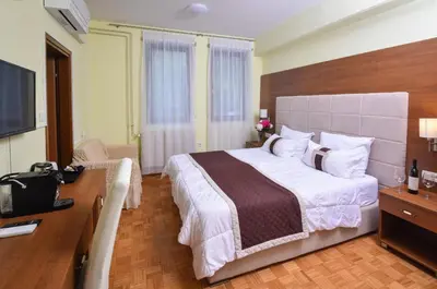 a hotel room with a large bed and a desk at Penzion Zaka in Bled