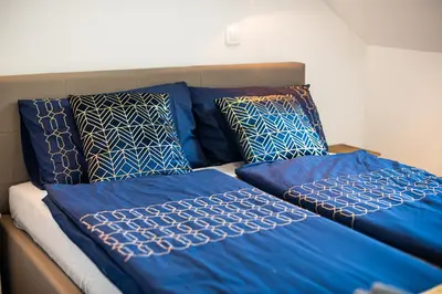 two blue comforters and pillows on a bed at Apartment A1 in Ljubljana