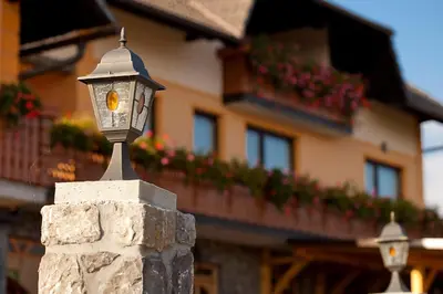 a street light on a stone wall in front of a building at Tourist Farm Škrbina in Otočec