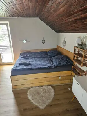 a bedroom with a bed with a wooden ceiling at Holiday Home NA VASI in Gorenja Vas