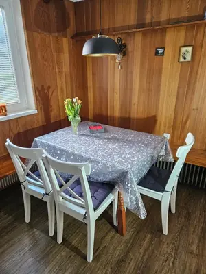 a white table with two chairs and a vase of flowers at Holiday Home NA VASI in Gorenja Vas