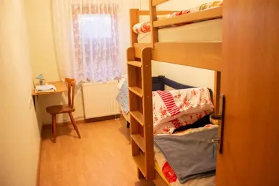 a room with a bunk bed with a desk and a window at Turistična kmetija Dreisiebner in Špičnik