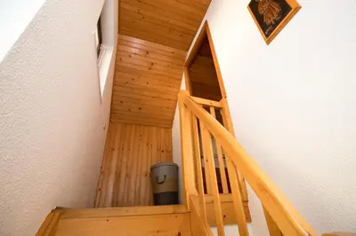 a wooden staircase in a house with a trash can at Počitniška hiša Žvan in Bohinj