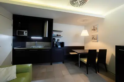 a kitchen with a sink and a table in a room at Apartments Trio in Kranjska Gora