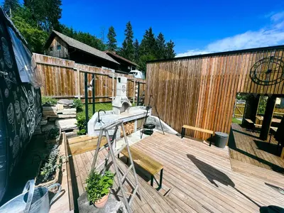a wooden deck with a bench and a fence at Glamping Langus in Topolšica