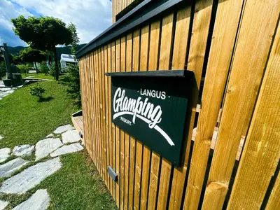 a sign on the side of a wooden building at Glamping Langus in Topolšica