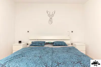 a bedroom with a bed with a blue comforter at Brlog in Zgornje Gorje