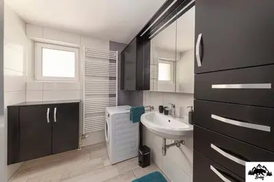 a bathroom with a sink and a toilet and a mirror at Brlog in Zgornje Gorje