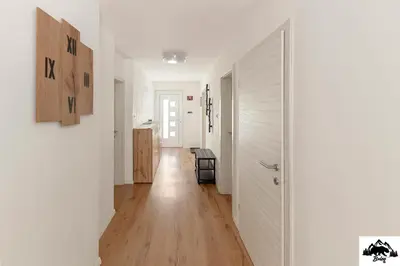 a hallway with white walls and a wooden floor at Brlog in Zgornje Gorje