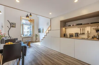 a kitchen and living room with white cabinets and a table at Old Quarter Residence in Ljubljana